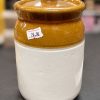 Cropped photo of a white and amber brown ceramic storage jar with lid