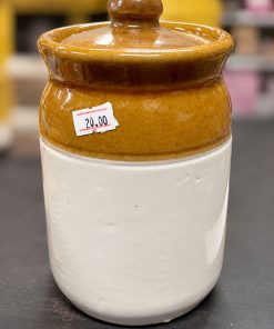 Cropped photo of a white and amber brown ceramic storage jar with lid