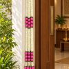 White Artificial Flower Garland with Pink Lotus Buds – 7 ft White and pink lotus-bud garland displayed beside a home doorway