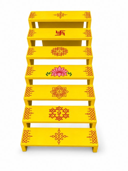Yellow 7-Step Golu Stand with Kolam Designs – 63 × 30 × 28 cm Yellow seven-step Golu stand with traditional kolam and lotus designs